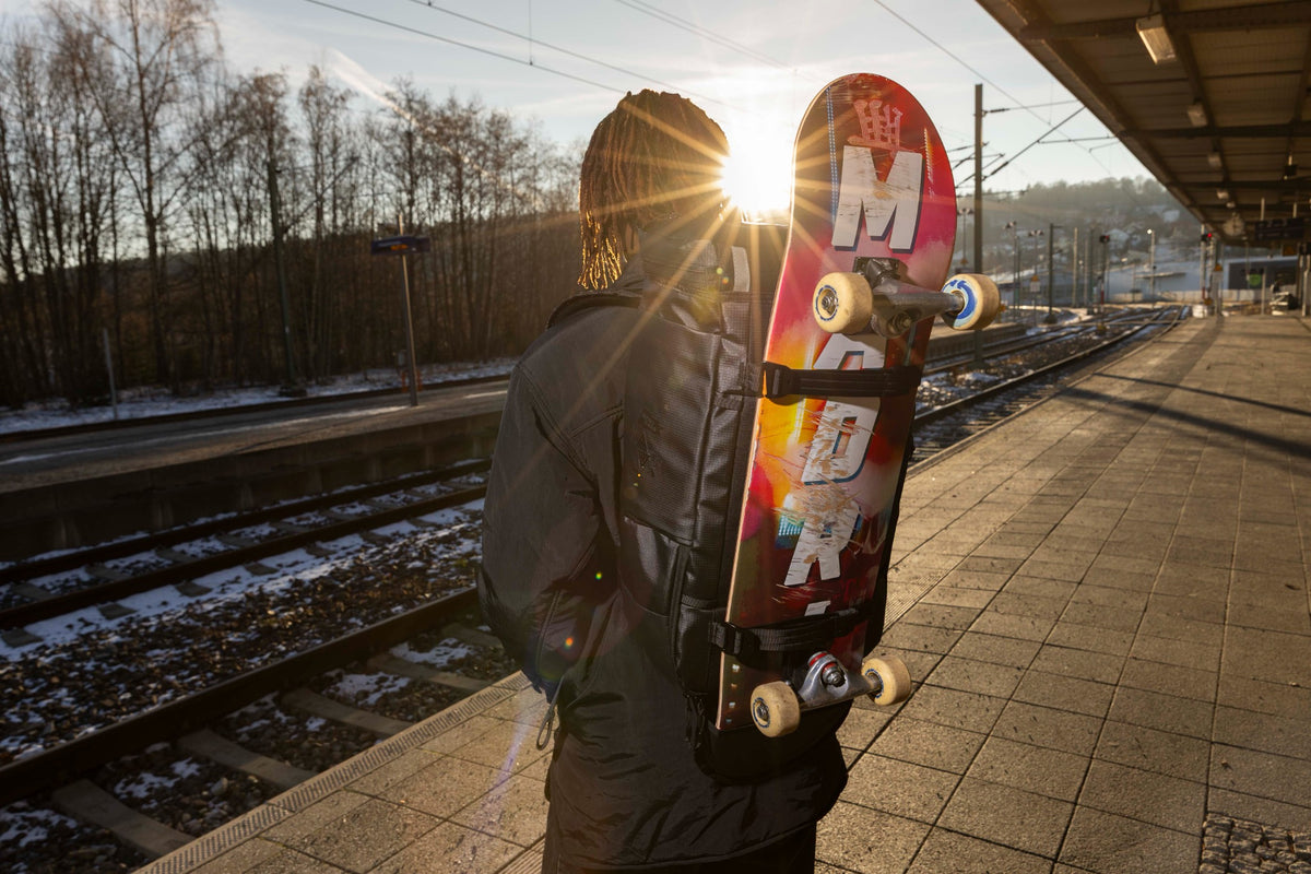 Nitro FIVE-O PRO Tough Black mit befestigtem Skateboard am Bahnhof
