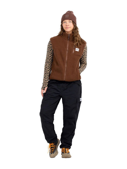 Eivy Fitted Outdoorhose in Schwarz kombiniert mit brauner Fleeceweste und gemustertem Langarmshirt.