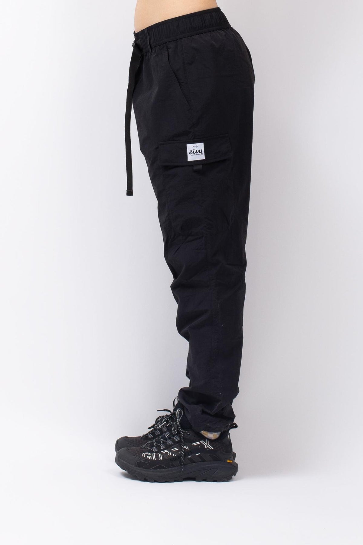 Schwarze Eivy Fitted Outdoorhose mit elastischem Bund, Kordelzug und seitlicher Cargotasche in Seitenansicht.